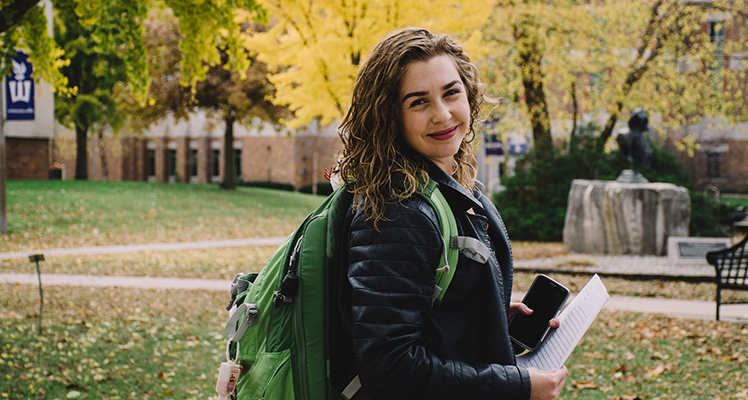 Smiling female student with backpack on campus