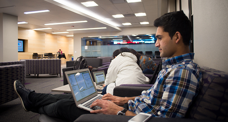 A student researches on his laptop in a study lounge on WSU campus. 