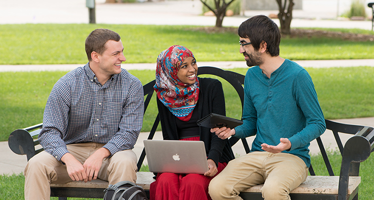Students talking on campus bench