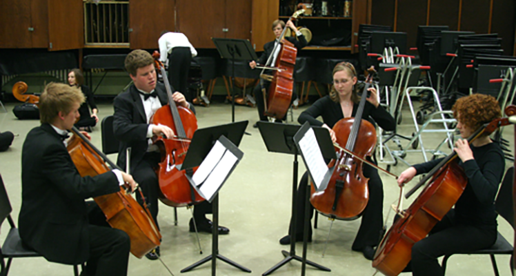 Students playing cellos in a circle