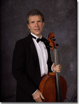Dr. Paul Vance stands with a cello.