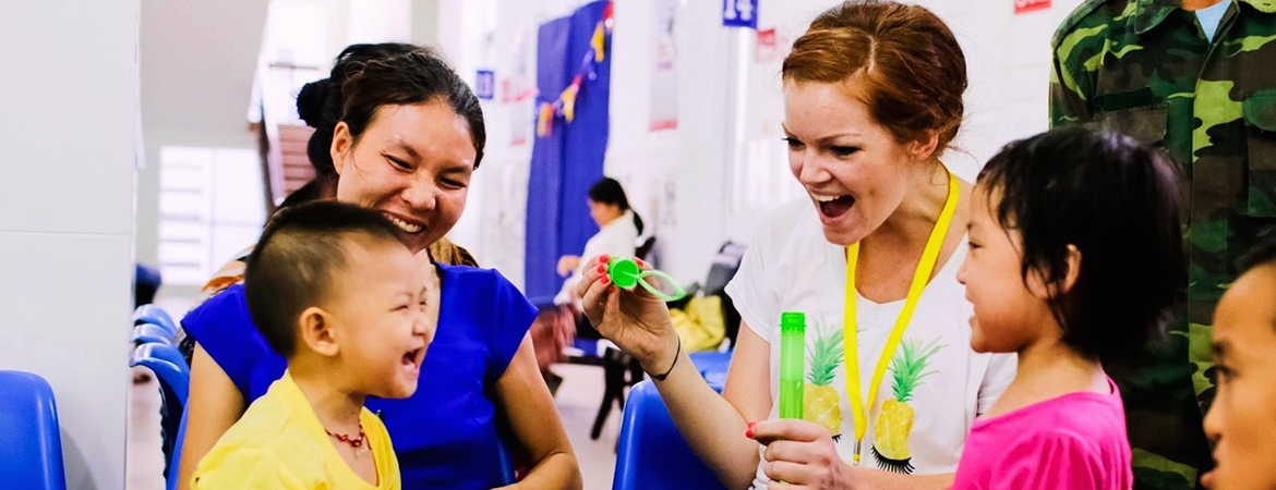 A female student interacts with a child during a community health event. 