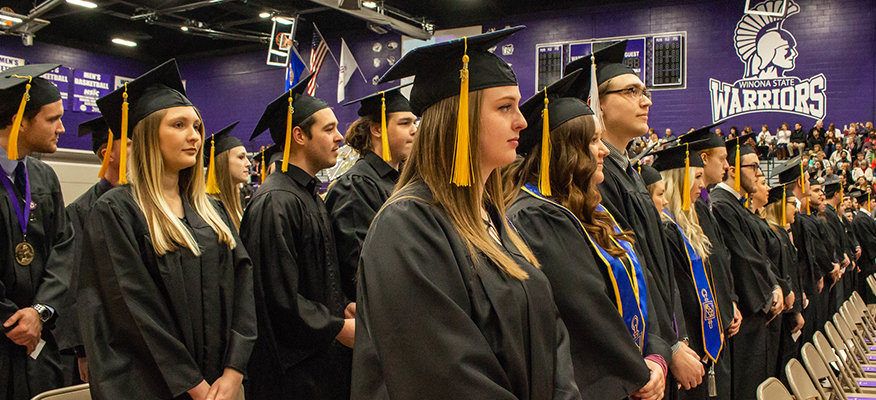 WSU graduates stand during the commencement ceremony.