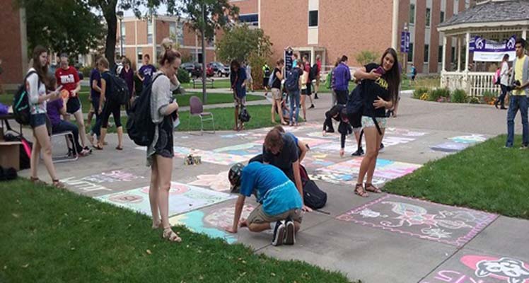 Student draw with chalk on campus sidewalks