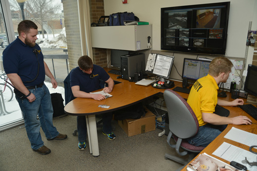 Three student guards staff the campus security communications center.